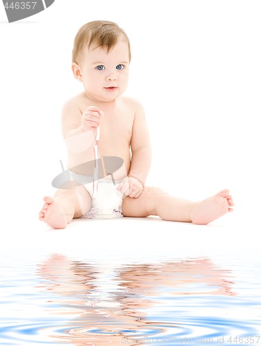 Image of baby boy in diaper with toothbrush