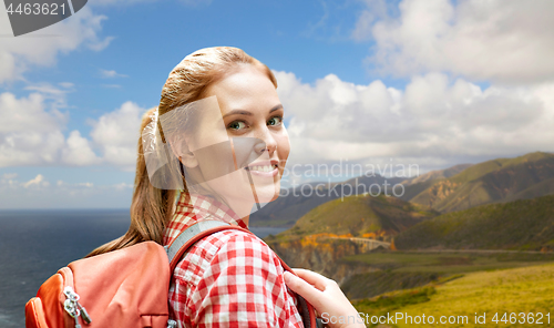 Image of smiling woman with backpack on big sur coast