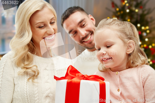 Image of happy family at home with christmas gift