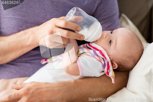 Image of close up of father feeding baby from bottle