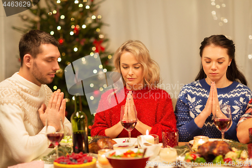 Image of friends praying before christmas dinner at home 