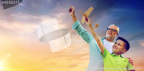 Image of senior man and boy with toy airplane over sky