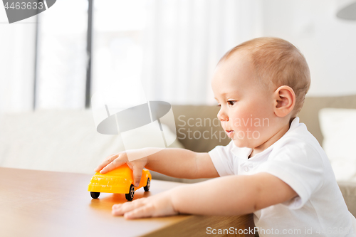 Image of baby boy playing with toy car at home