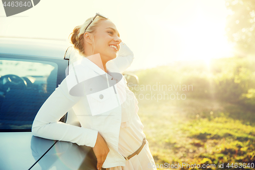 Image of happy teenage girl or young woman near car