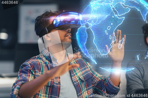 Image of man in vr headset with earth hologram at office