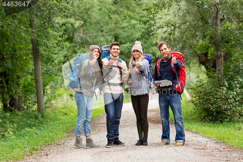 Image of friends hiking with backpacks and show thumbs up