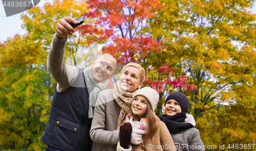 Image of family taking selfie by smartphone in autumn park