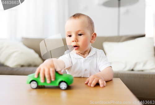 Image of baby boy playing with toy car at home