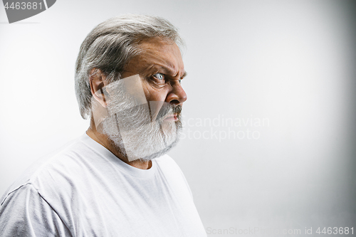 Image of Senior man with disgusted expression repulsing something on white