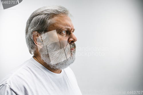 Image of The profile of serious businessman looking away against white background.