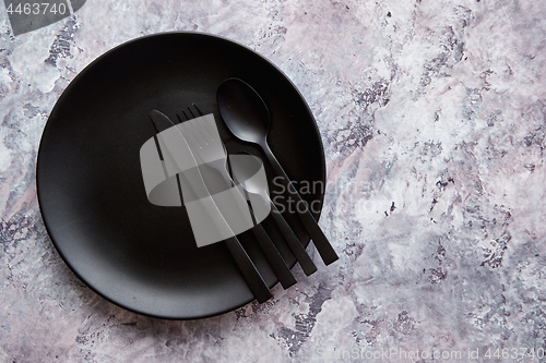 Image of Top view of black empty plate on marble stone background