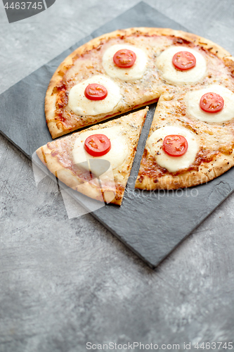 Image of Homemade pizza with tomatoes, mozzarella