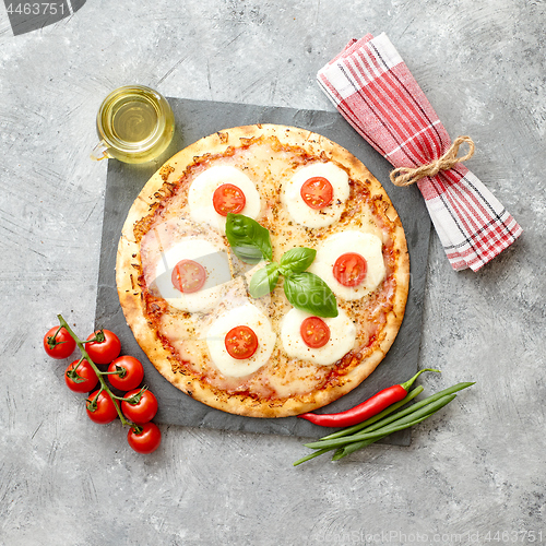 Image of Homemade pizza with tomatoes, mozzarella