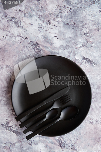 Image of Top view of black empty plate on marble stone background