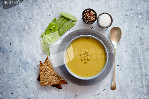 Image of Green pea cream soup in grey bowl