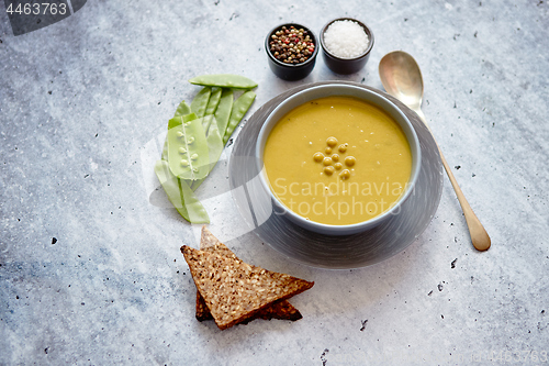 Image of Green pea cream soup in grey bowl