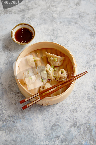 Image of Delicious chinese dumplings served in wooden bamboo steamer