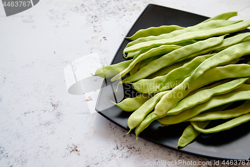 Image of Black ceramic plate with fresh green bean pods