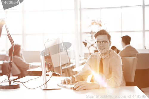 Image of Young businessman using computer at work