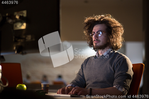 Image of man working on computer in dark office