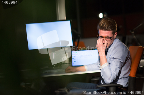 Image of man working on computer in dark office