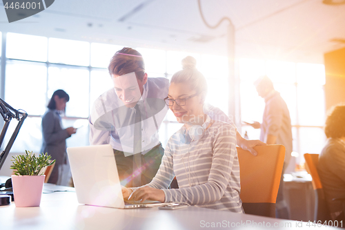 Image of Young businessman helping his colleague at the work