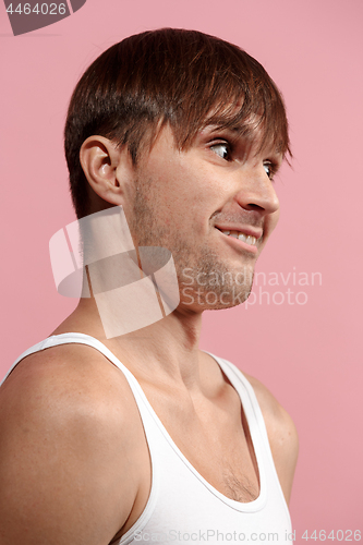 Image of The happy man standing and smiling against pink background.