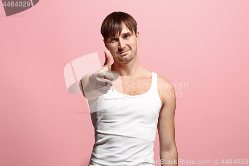 Image of The happy man standing and smiling against pink background.