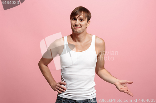 Image of The happy man standing and smiling against pink background.
