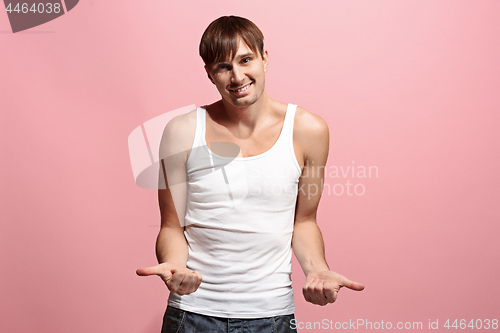 Image of The happy man standing and smiling against pink background.