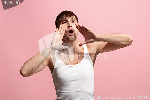 Image of Isolated on pink young casual man shouting at studio