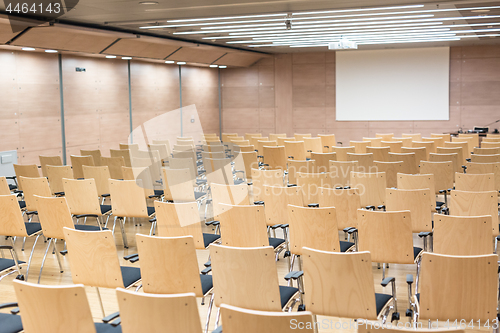 Image of Empty wooden seats in a cotmporary lecture hall.