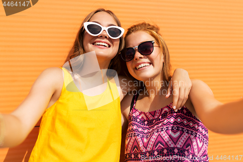 Image of teenage girls taking selfie outdoors in summer