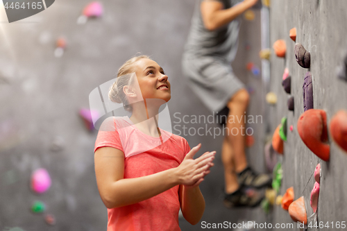 Image of man and woman climbing a wall at indoor gym