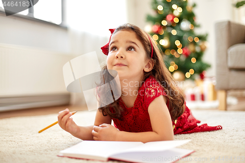 Image of little girl making christmas wish list at home