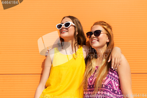 Image of teenage girls in summer clothes hugging outdoors