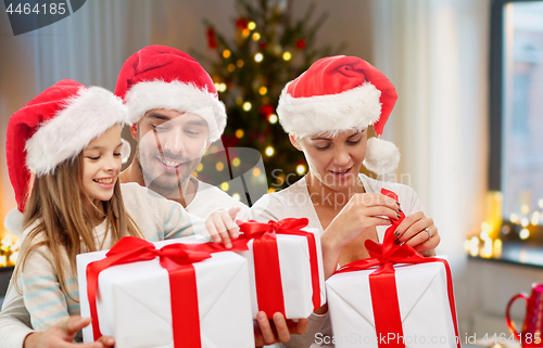 Image of happy family with christmas gifts at home