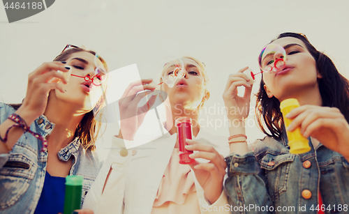 Image of young women or girls blowing bubbles outdoors