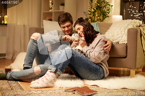 Image of happy couple with cat at home