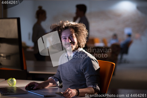 Image of man working on computer in dark office