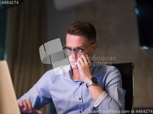 Image of man working on laptop in dark office