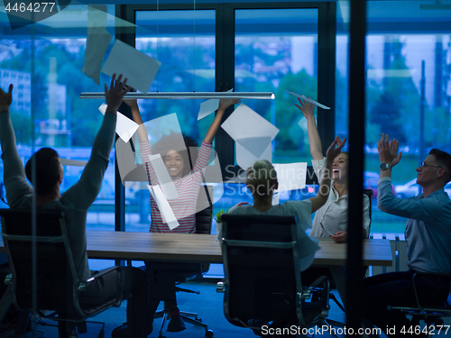 Image of multiethnic Group of young business people throwing documents