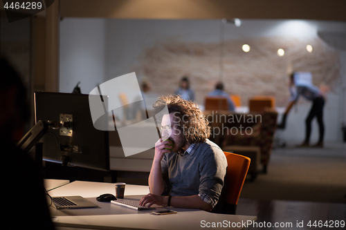 Image of man working on computer in dark office