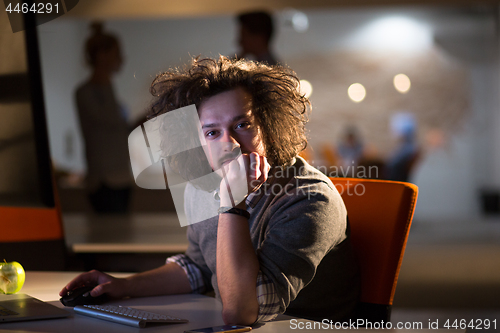 Image of man working on computer in dark office