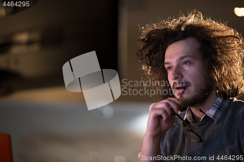 Image of man working on computer in dark office