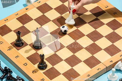 Image of soccer ball of chess pieces on the board