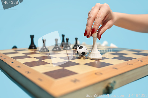 Image of soccer ball of chess pieces on the board