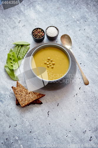 Image of Green pea cream soup in grey bowl