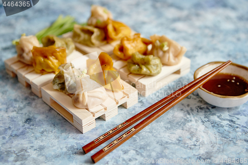 Image of Delicious mixed kinds of chinese dumplings served on wooden stands