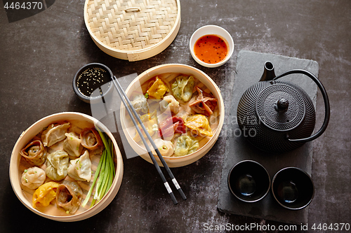 Image of Oriental traditional chinese dumplings served in the wooden steamer